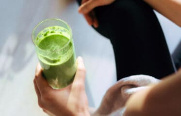 Person holding a green smoothie